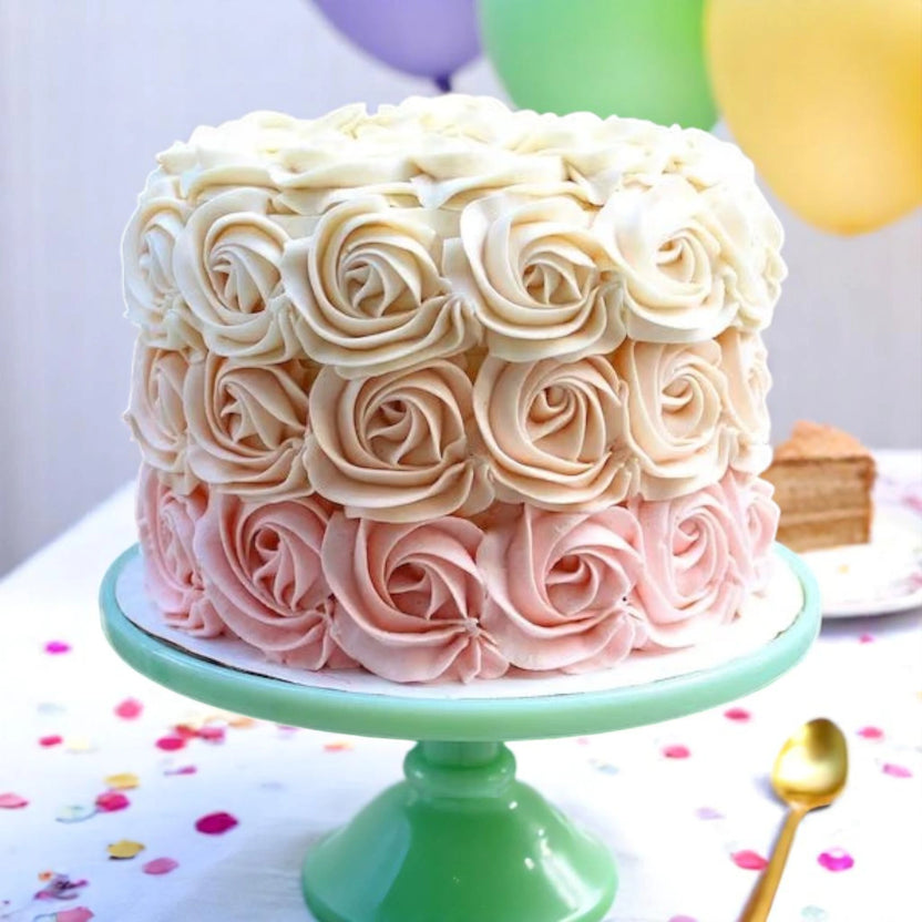 Heavenly Rose Cake with ombre rose pattern frosting in white, peach, and pink on a green cake stand. Ideal for weddings and anniversary gifts. Main image