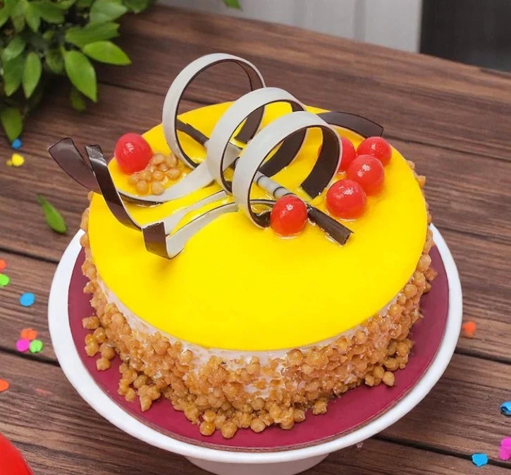 Round Butterscotch Cake with caramel glaze, roasted nut coating, and cherry-chocolate garnish, perfect for celebrations and dessert lovers.
