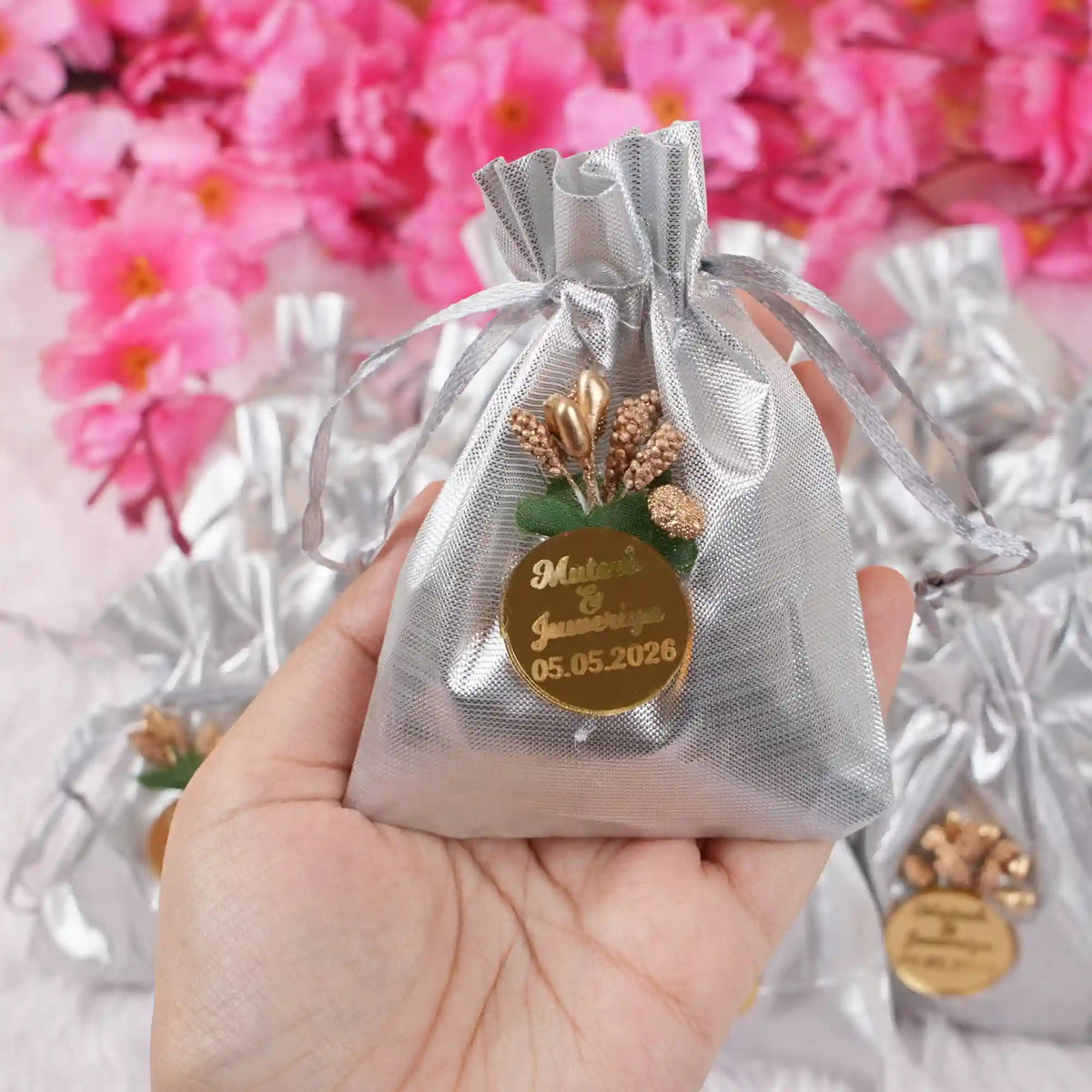 Handheld silver Nikah Favor Dry-Fruit Potli with custom tag, ideal for elegant Muslim wedding favors and celebration essentials.