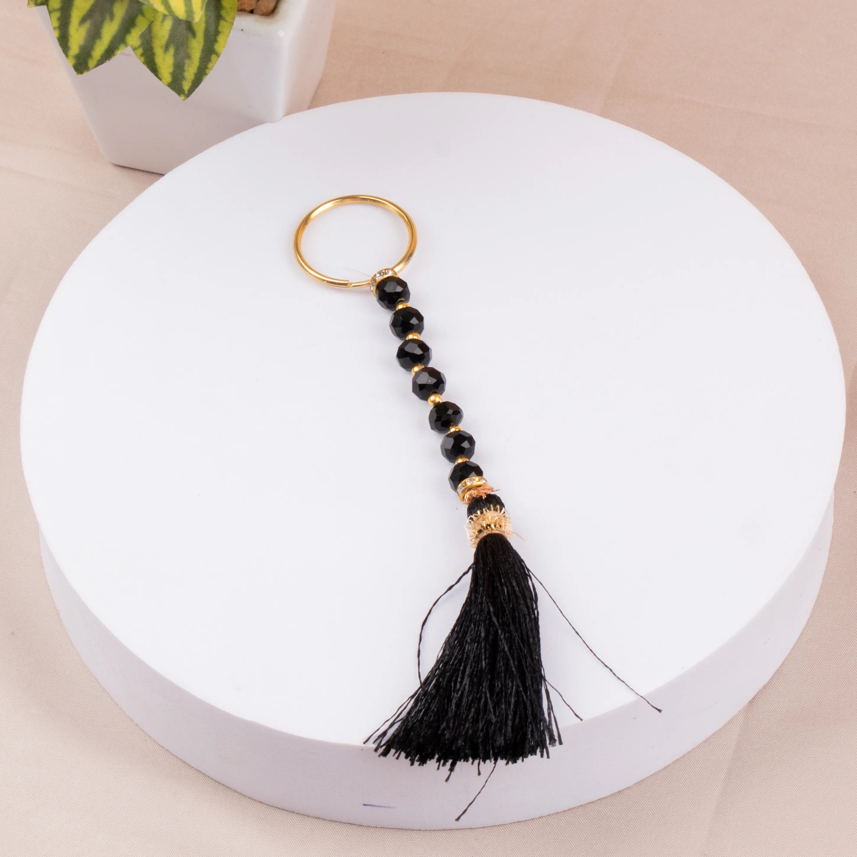 Black tasbeeh keychain with tassel from Raah-e-Makkah Safar Essentials - Luxury Hajj Umrah Hampers, a spiritual keepsake for pilgrims.