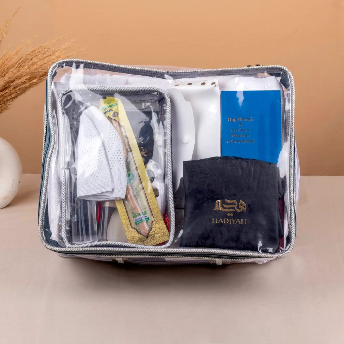 Packing cube with travel essentials including a book and black pants on a beige background