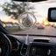 Decorative car hanging with tassel inside a car during sunset.
