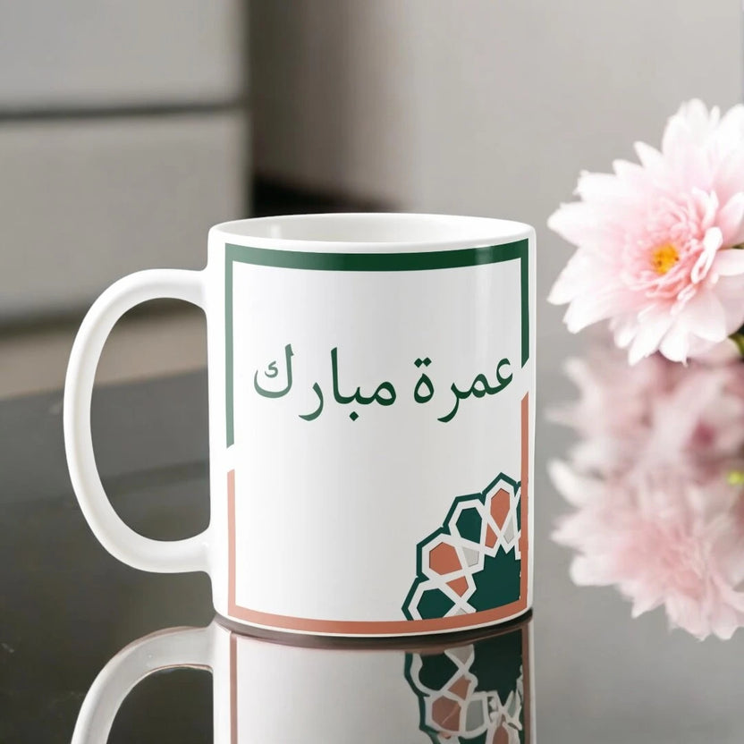 Umrah Mubarak Floral Mug with Arabic script and geometric floral design, 350 ml ceramic drinkware ideal for Umrah return gifts. Main image