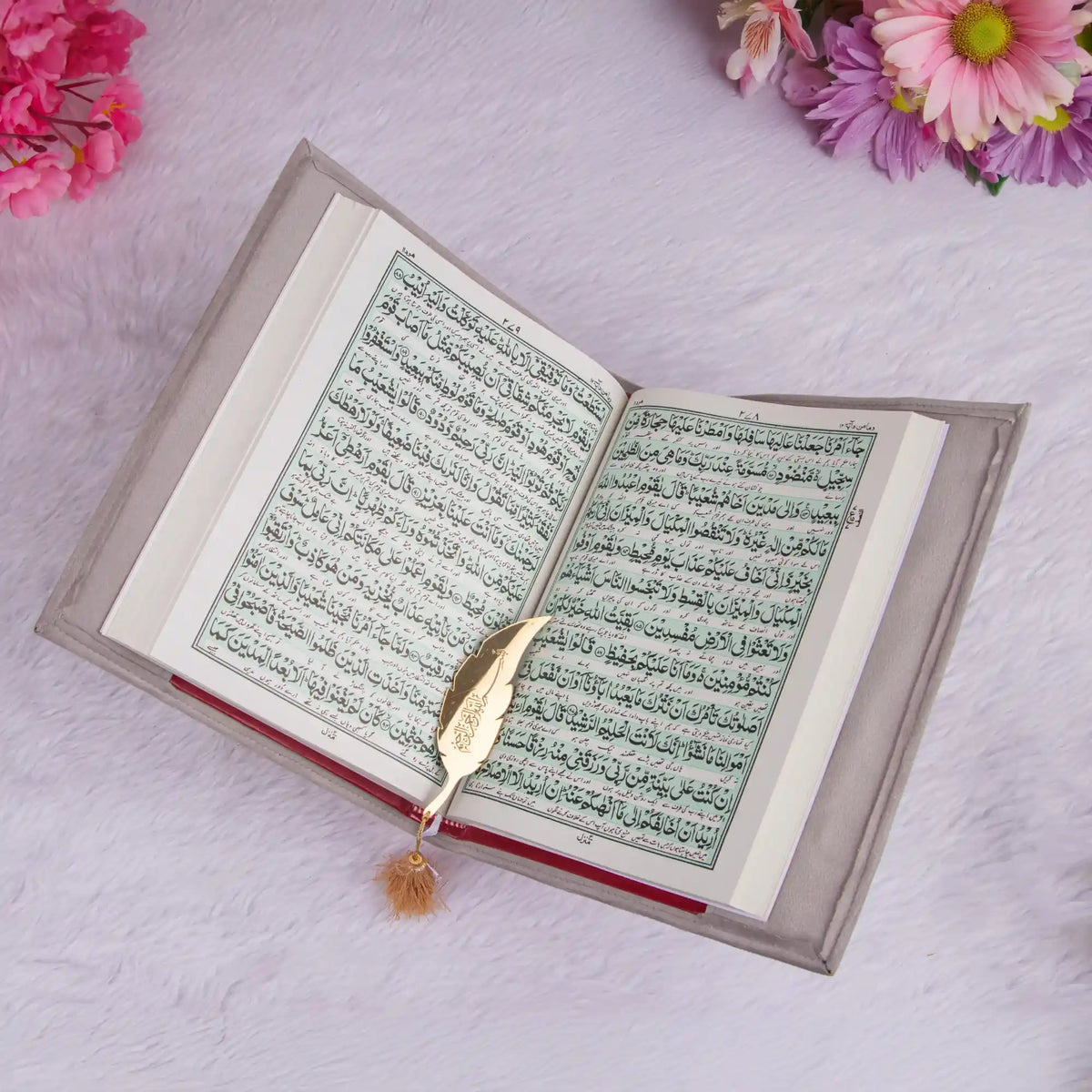 Open book with a decorative bookmark on a light pink background with flowers