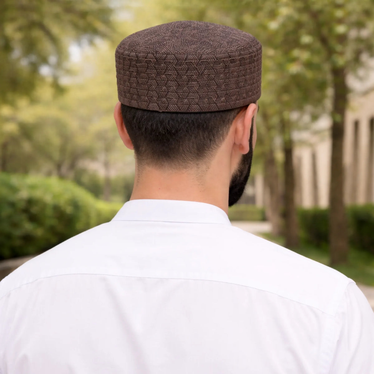 Man wearing brown patterned prayer cap outdoors for Islamic prayer