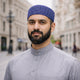 Man wearing blue prayer cap, traditional Islamic headwear for men