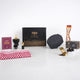 Front display of the Noble Ibadah Men's Hamper by Hadiyah, featuring a black gift box surrounded by a ghutra, Islamic book, bakhoor burner, prayer cap, miswak, and Ajwa dates.