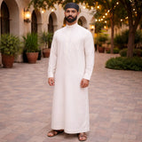 Back view of man in white dress and black prayer cap, elegant Islamic attire for prayer