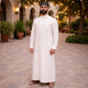 Back view of man in white dress and black prayer cap, elegant Islamic attire for prayer