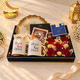 Gift set with candles, flowers, and a box on a fluffy white surface