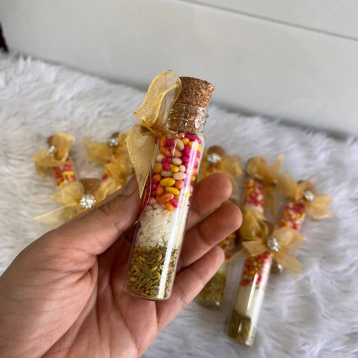 Hand holding a Shahi Mix Sounf Bottle filled with colorful sweets and fennel, designed for Nikah wedding favors and traditional gifting.