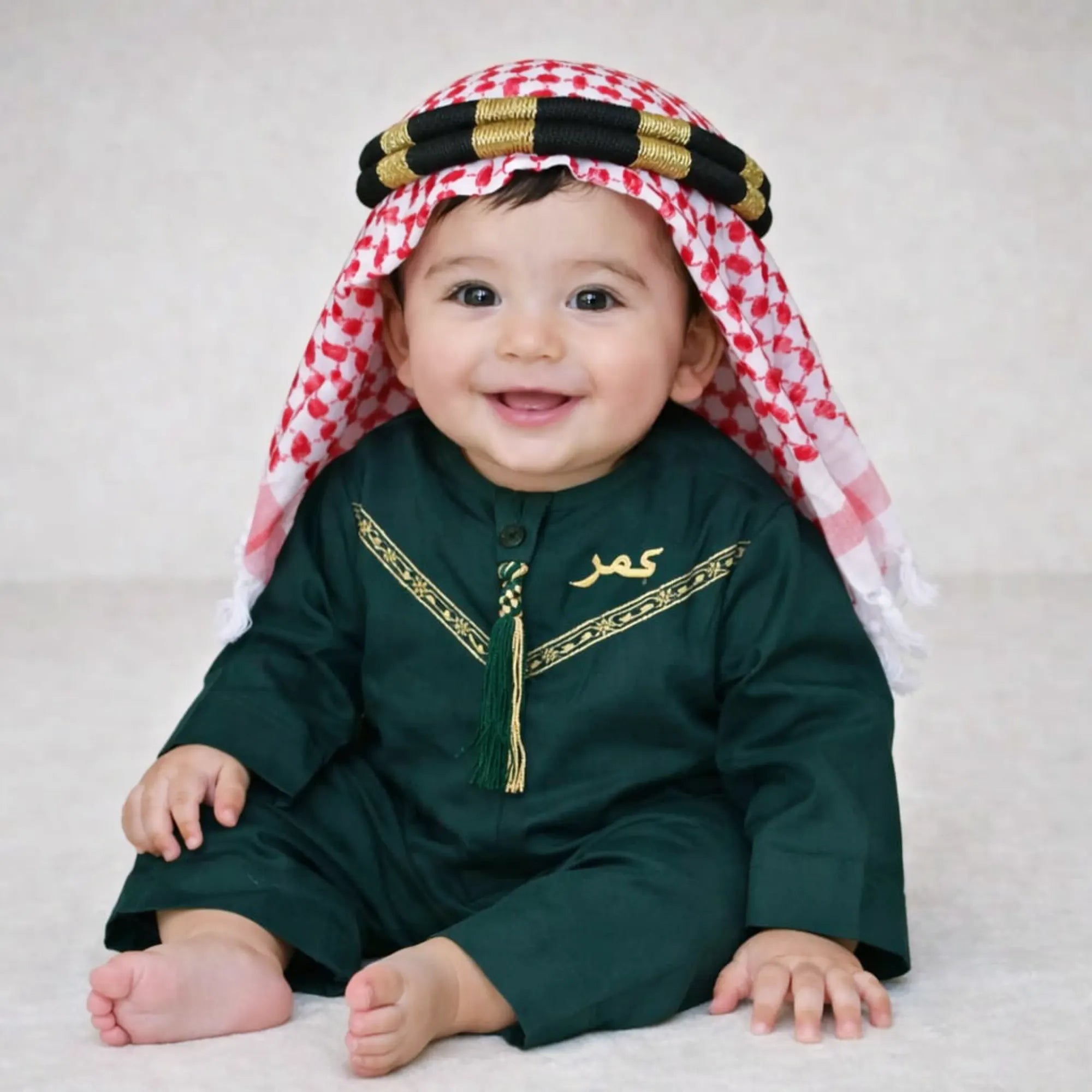 Baby boy wearing traditional green thobe with gold embroidery and tassel Main image