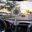 Decorative hanging car ornament with tassel on a car dashboard.
