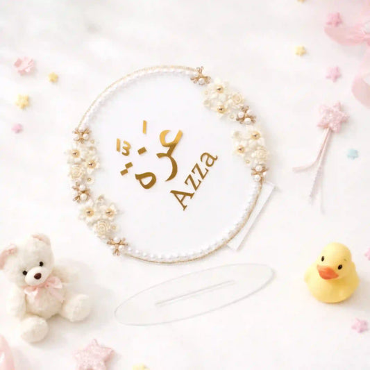 Kids Floral Pearl Name Frame with Stand featuring gold Arabic and English name 'Azza', adorned with white roses and pearls. Ideal for nursery décor or personalized gifts.