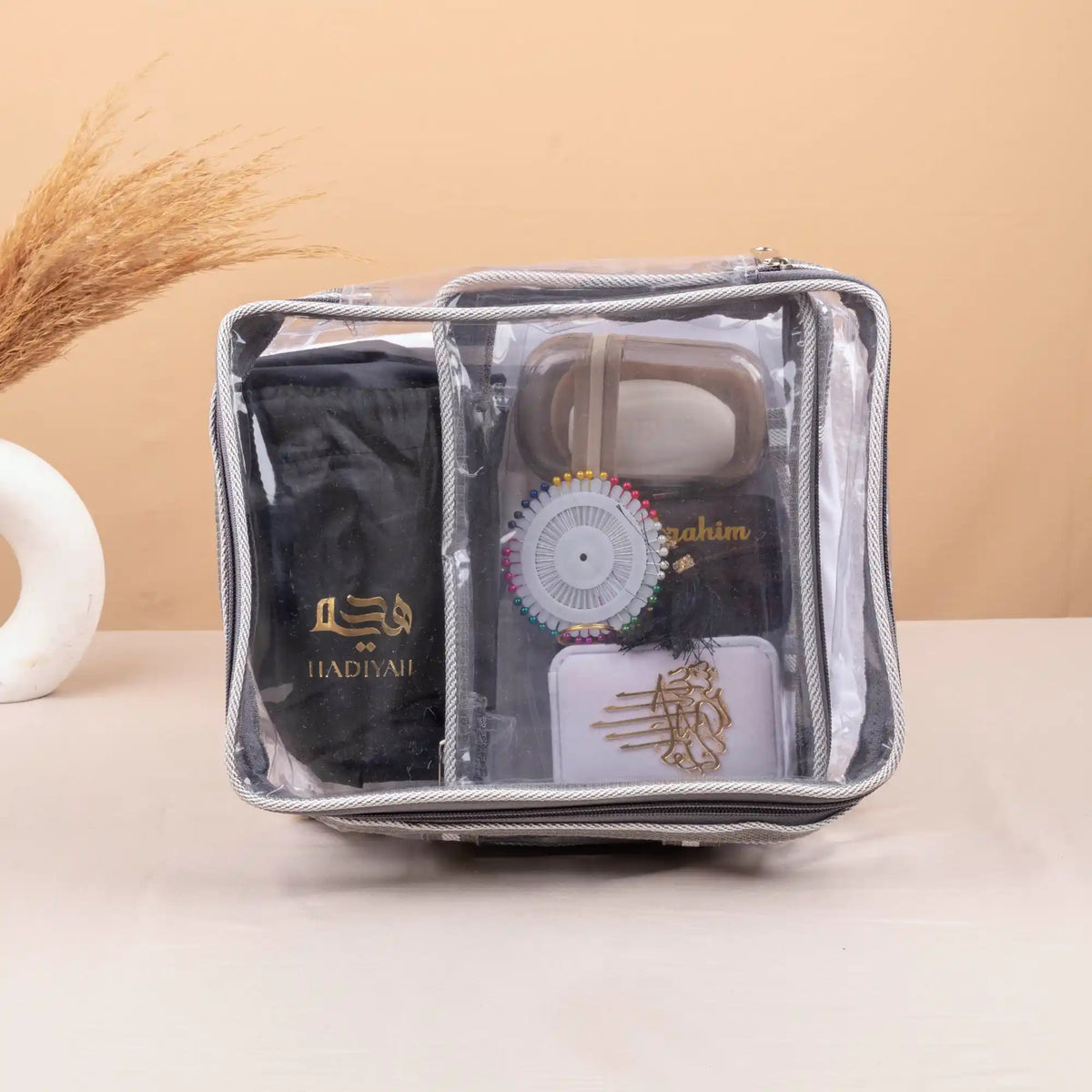 Compact transparent travel pouch from Labbaik Nisaa Women's Safar Essentials Kit with organized Hajj & Umrah items including hygiene and self-care tools.