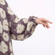 Close-up of woman in floral prayer dress with hand on chest