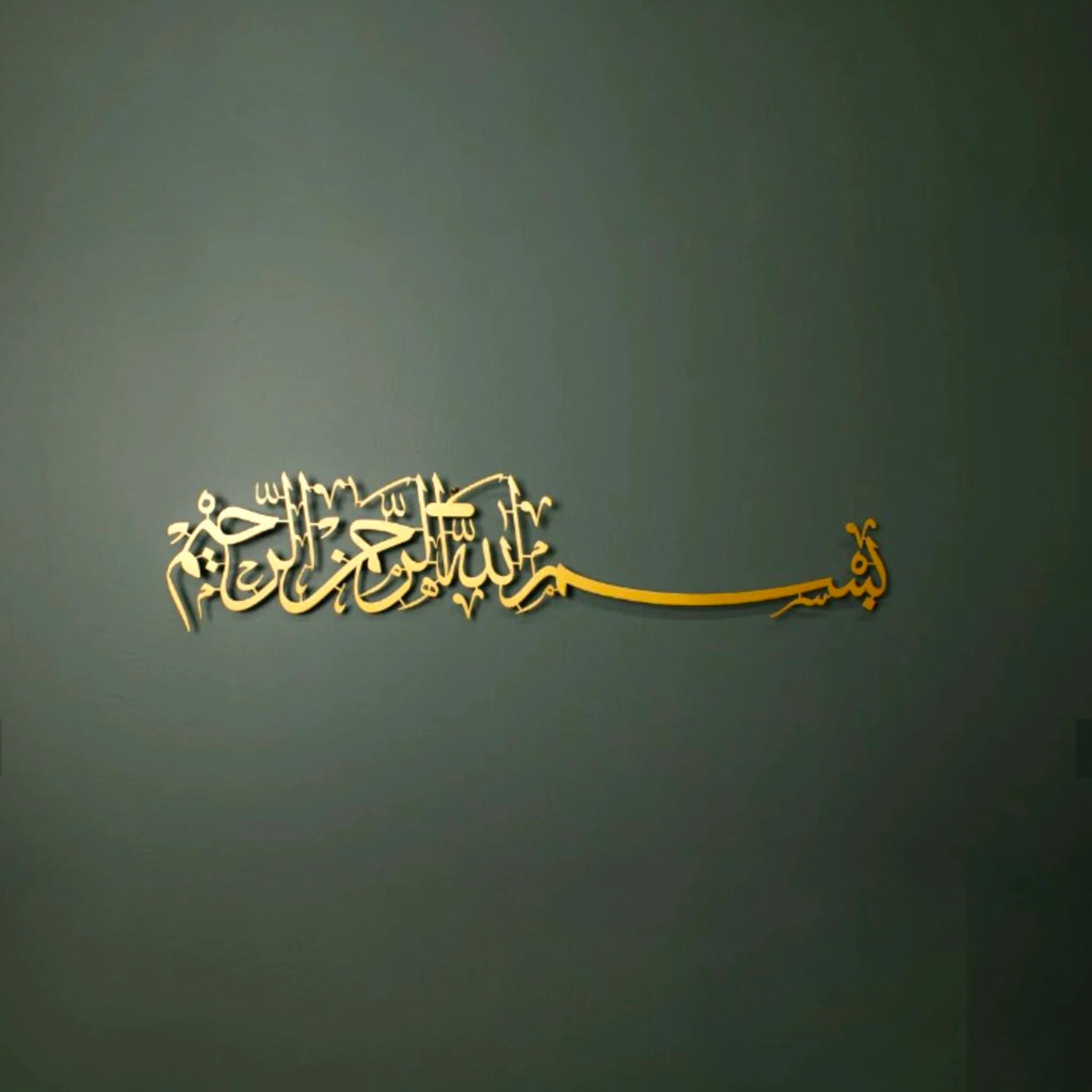 Gold acrylic Bismillah Calligraphy Wall Decor, 36x8 inches, displayed on a green wall for home or office spiritual ambiance.