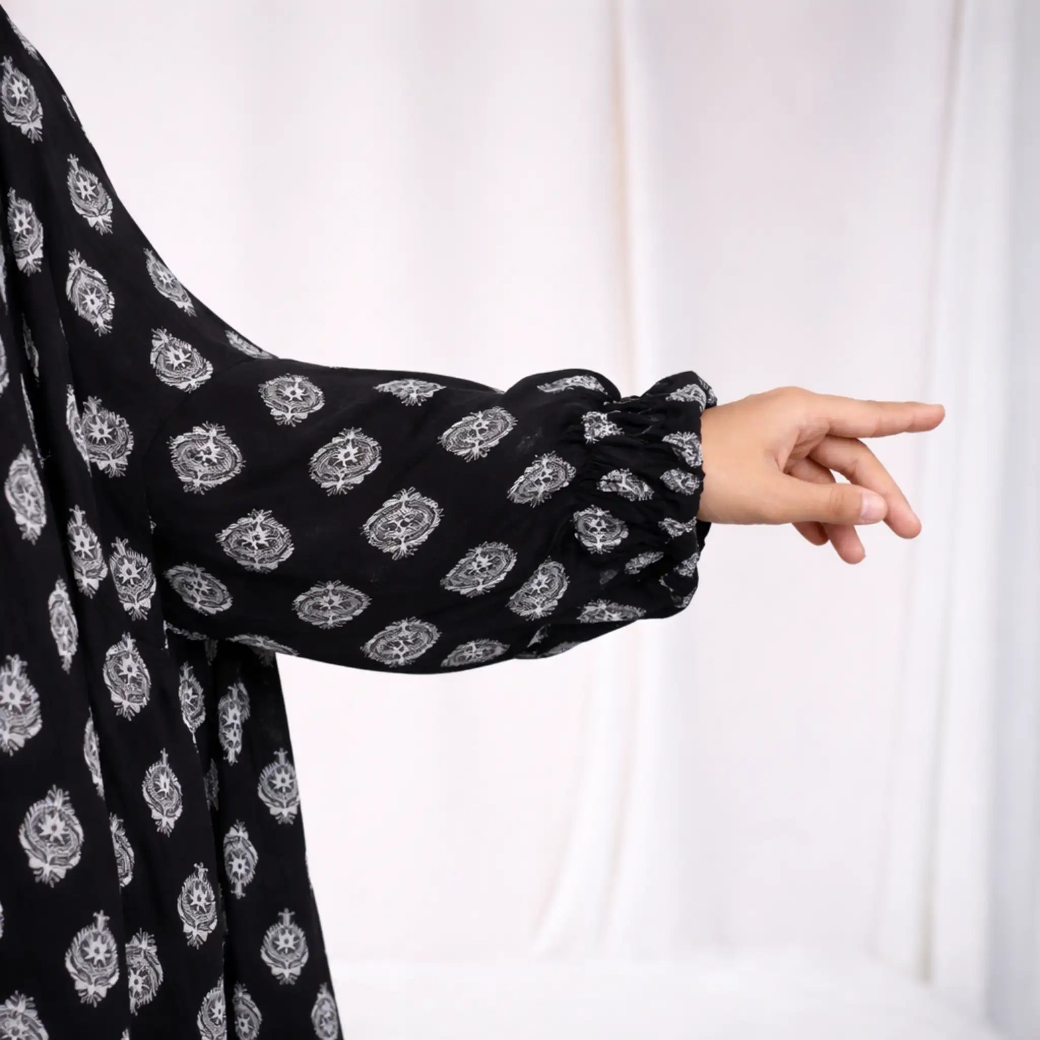 Close-up of Prayer Dress 2 sleeve with elastic cuff detail, highlighting the soft chiffon fabric and intricate white pattern.