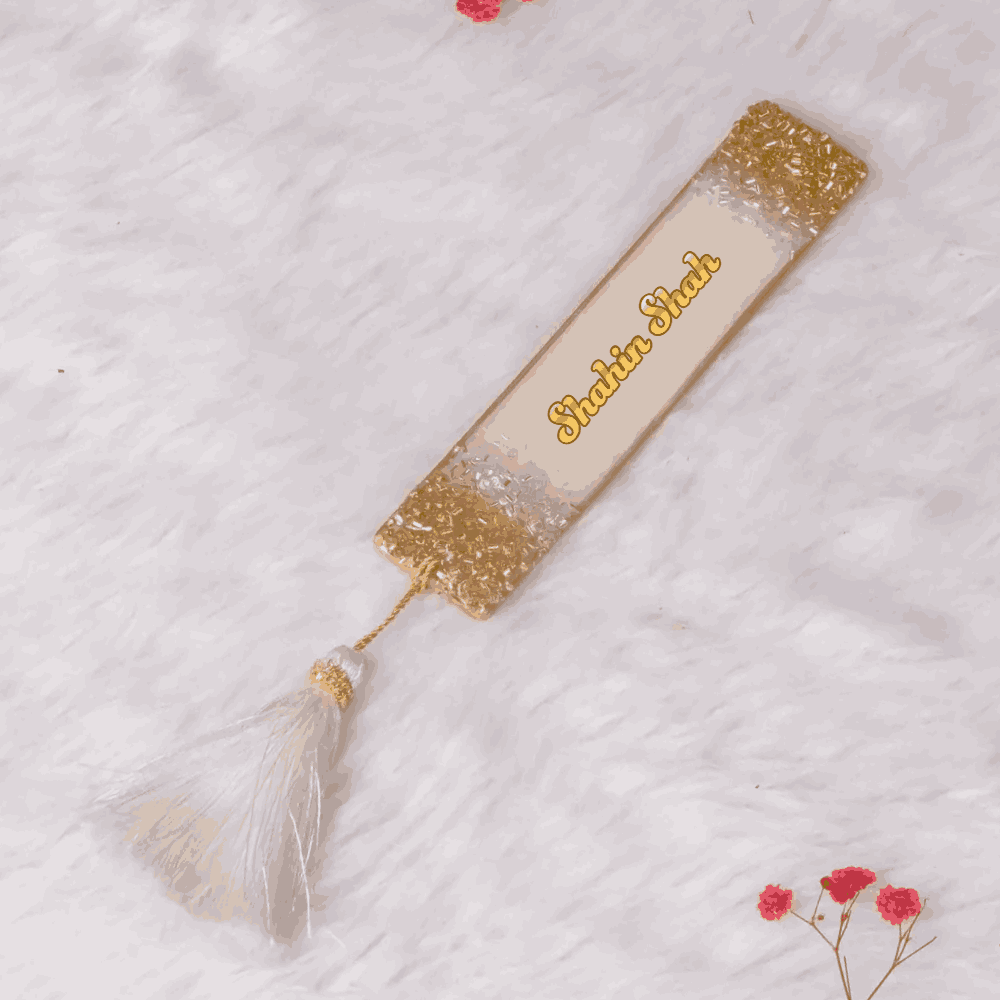 Offwhite personalised designer bookmark with gold glitter edges and name 'Shaista Shah' in calligraphy. Elegant gift for book lovers.