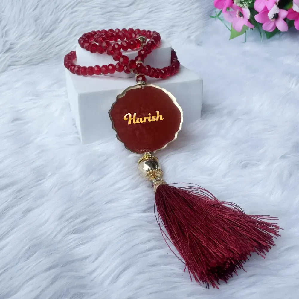 Personalized maroon acrylic Tasbeeh with name tag and tassel from the Maroon Sequence Rehal Hamper - Luxury Quran Gift Set. Customizable Islamic gift.