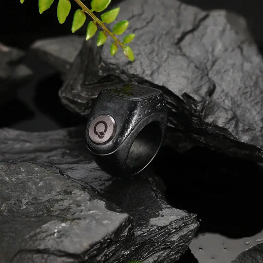 Waterproof black Zikr Ring Flex Pro placed on rocks, showcasing durable design for Islamic prayer and tasbih tracking.