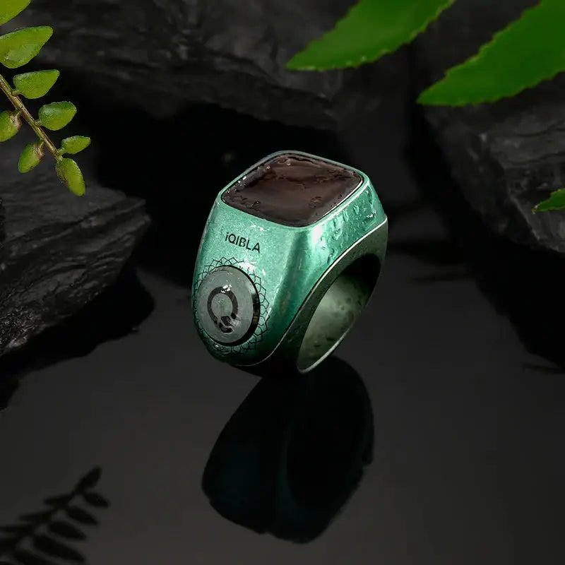 Green Smart Zikr Ring Flex Pro on black stones, featuring OLED display and tasbih counter for daily zikr.