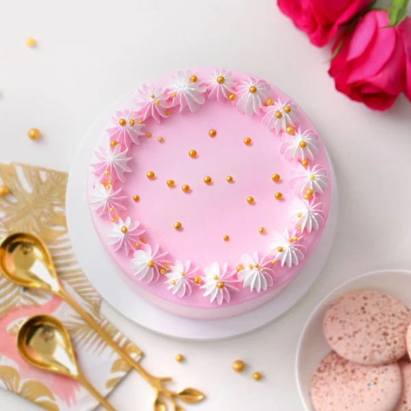 Soft Vanilla Cake - Simple Delights featuring smooth pink icing, daisy-like cream decorations, and golden pearls. Perfect for anniversaries or celebrations.