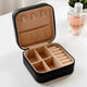 Mini Jewelry Box - Personalized Organizer in black with beige interior, featuring ring rolls, compartments, and earring hooks for compact storage.