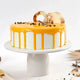 Round creamy butterscotch cake with caramel drip, layered sponge, and artistic chocolate garnishes, perfect for dessert lovers and festive occasions.