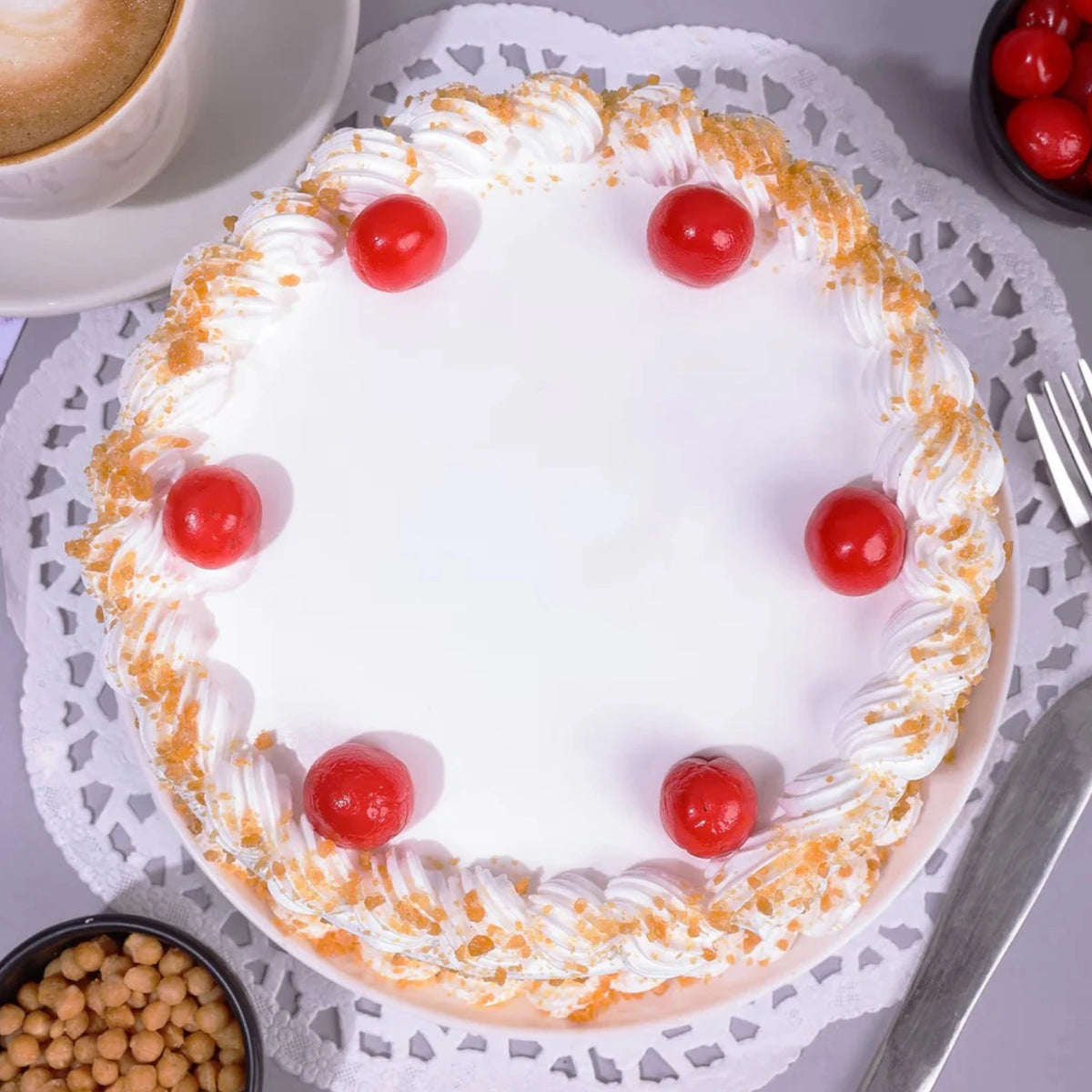 Butter Scotch Cake with white frosting, caramel crunch edges, and red cherries on top. Ideal for parties and same day delivery orders.