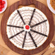 Top view of Butterscotch Cake Online featuring cream web design, chocolate sticks, cherry center, and crunchy caramel bits. Ideal for celebrations.