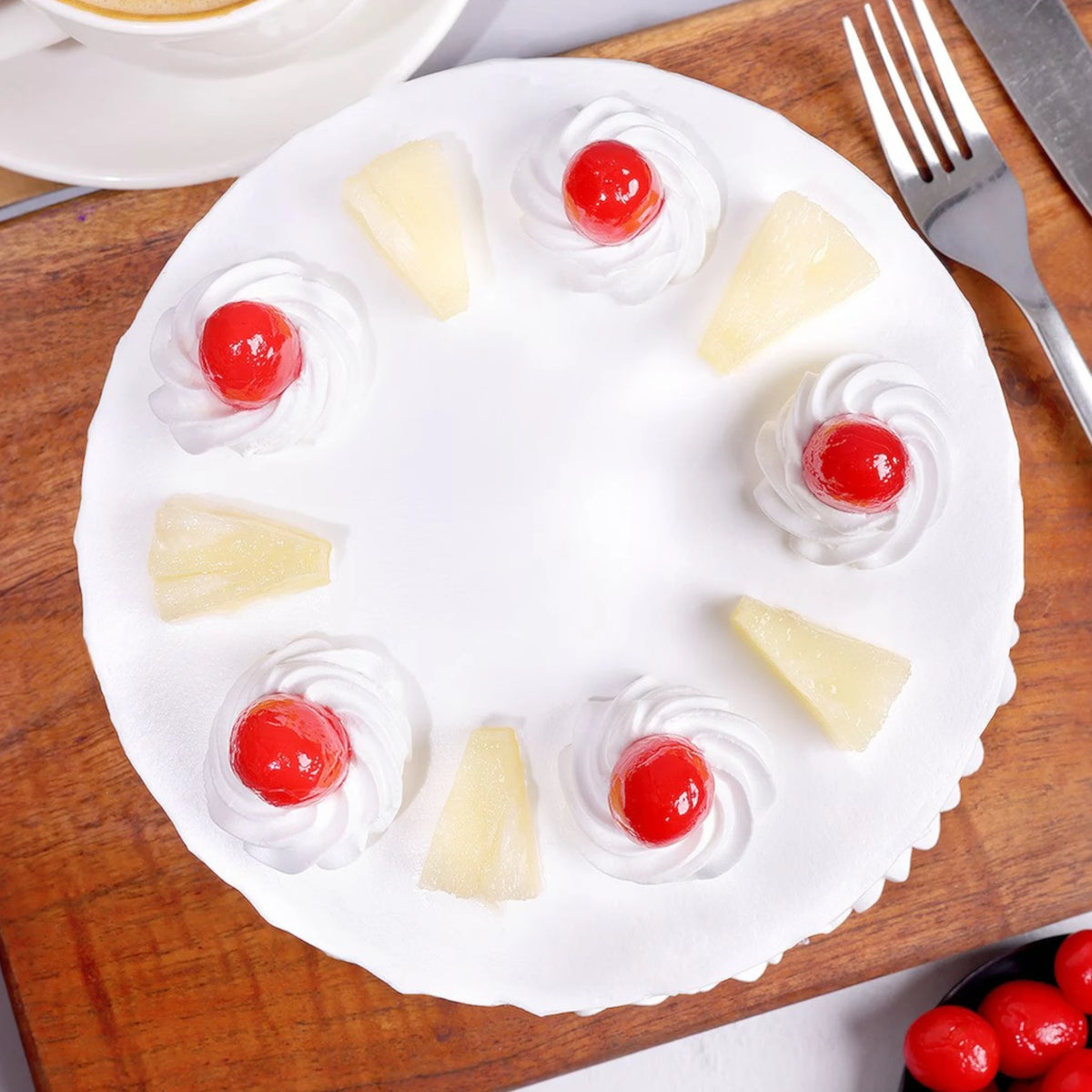 Pineapple Cake for Any Occasion topped with whipped cream, cherries, and pineapple slices on a wooden board. Ideal for birthdays and anniversaries.