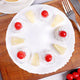 Pineapple Cake for Any Occasion topped with whipped cream, cherries, and pineapple slices on a wooden board. Ideal for birthdays and anniversaries.
