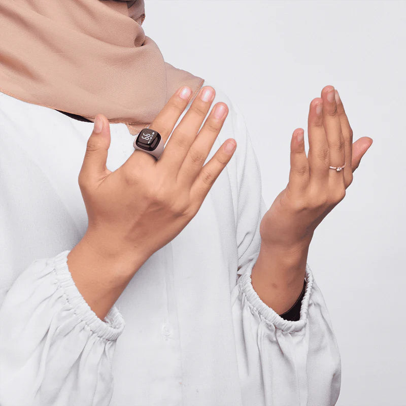Muslim woman wearing Noor Zikr Ring - Smart Tasbeeh during prayer. Tracks Zikr effortlessly with modern Islamic tech.