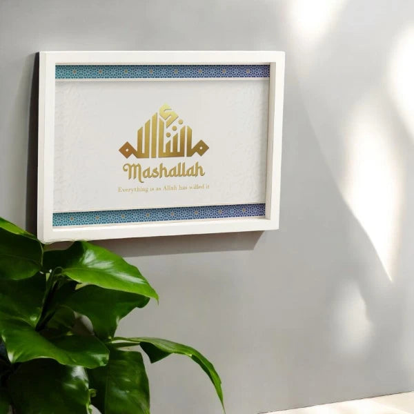 Mashallah Wooden Home Decor Frame in A3 size mounted on a wall near green indoor plant, showcasing gold Islamic calligraphy and handmade detailing.