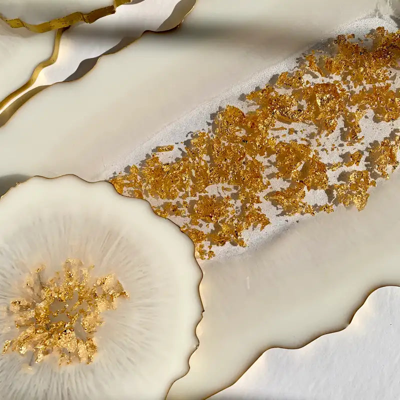 Close-up of a decorative surface with gold leaf and white marble-like texture