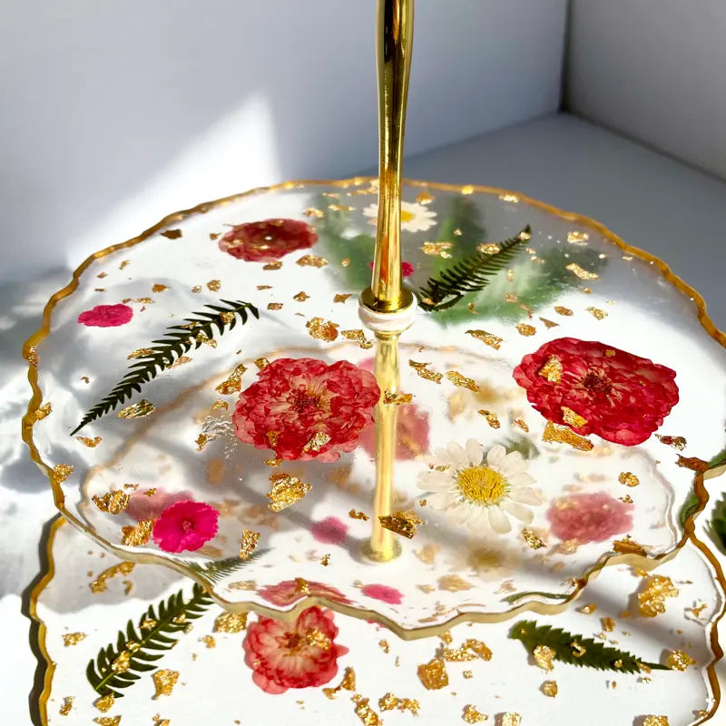 Decorative umbrella with floral design and gold accents on a white surface