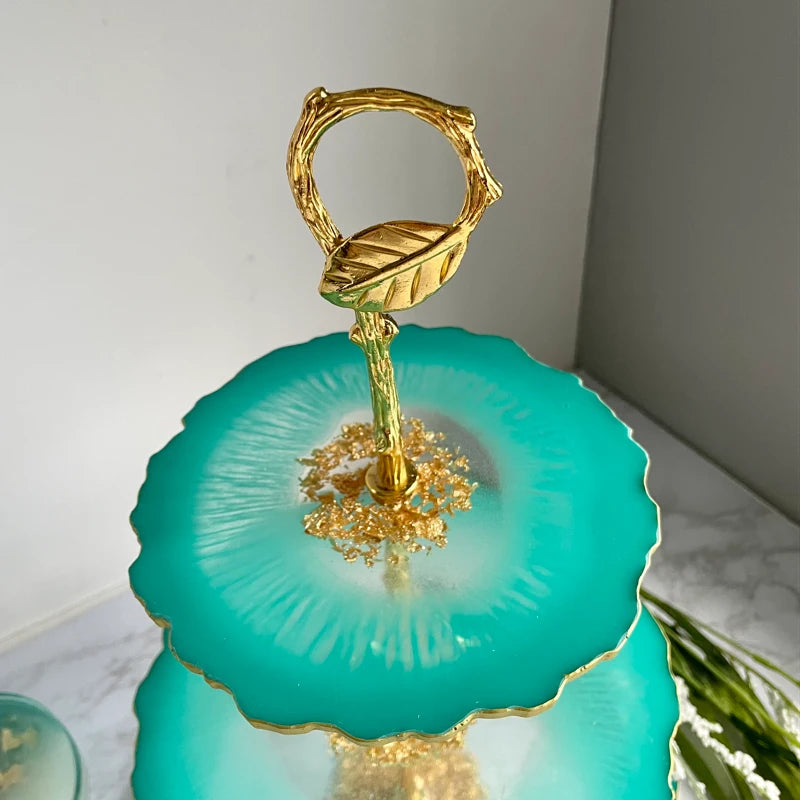 Decorative item with gold accents and a green base on a marble surface.