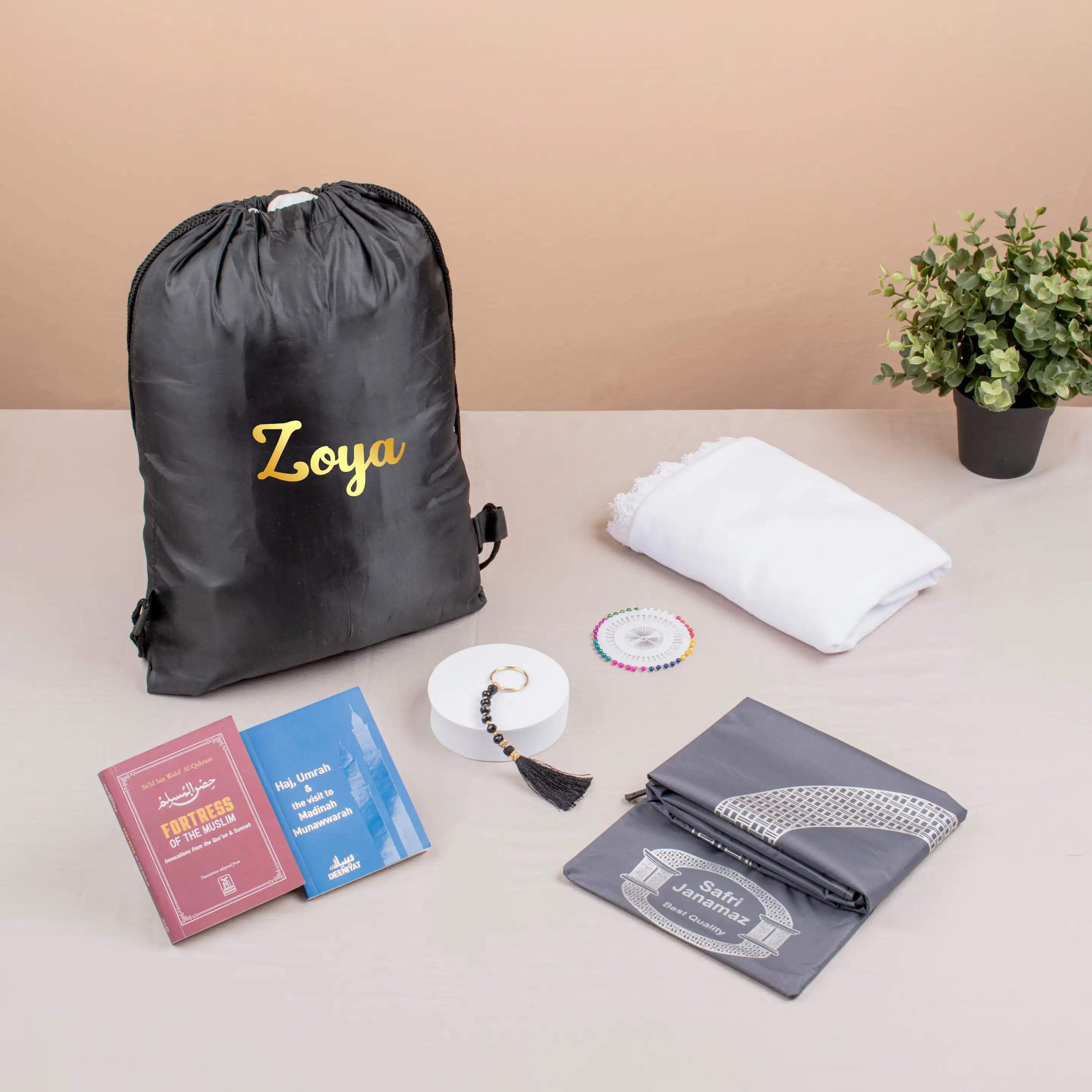 Safar-e-Imaan Women's Set - Hajj Umrah Travel Kit with personalized drawstring bag, hijab, prayer mat, tasbeeh, and guidebooks for women.