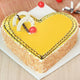 Romantic Butterscotch Heart Shape Cake featuring creamy caramel topping, crunchy edges, and decorative chocolate curls. Perfect for special occasions.