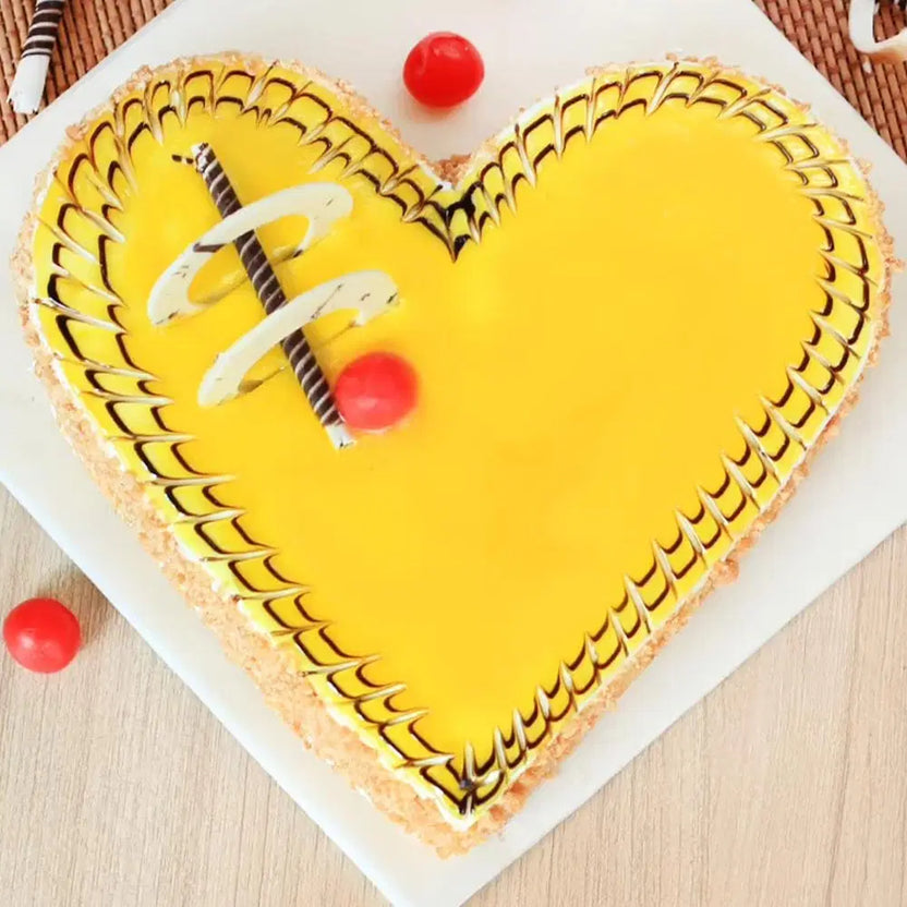 Butterscotch Heart Shape Cake with yellow caramel glaze, chocolate swirl design, and cherry topping. Ideal for romantic surprises and anniversaries. Main image