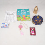 Top-down flat lay of the pink-themed Imaan Play & Pray Kids Hamper contents, including a Basic Duas for Children book, a Ramadan mosque coloring sheet, a box of 10 crayons, a pink digital tasbeeh, a pink 33-bead tasbeeh with a tassel, a mini golden lantern, and a blue tin of Danish Butter Cookies.